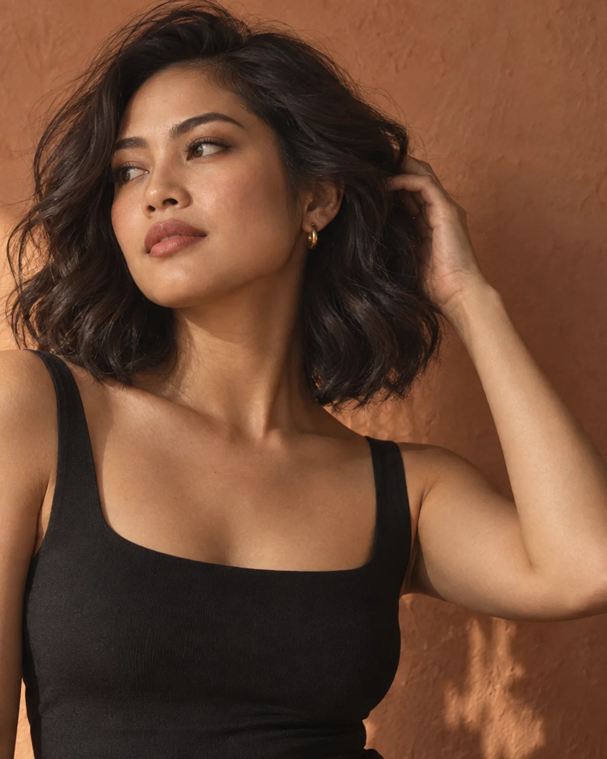 A woman with a softly waved dark bob in warm afternoon light